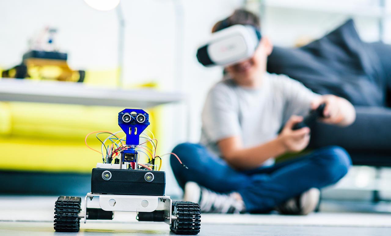 Kid driving a robot car with a vr head set and game controller